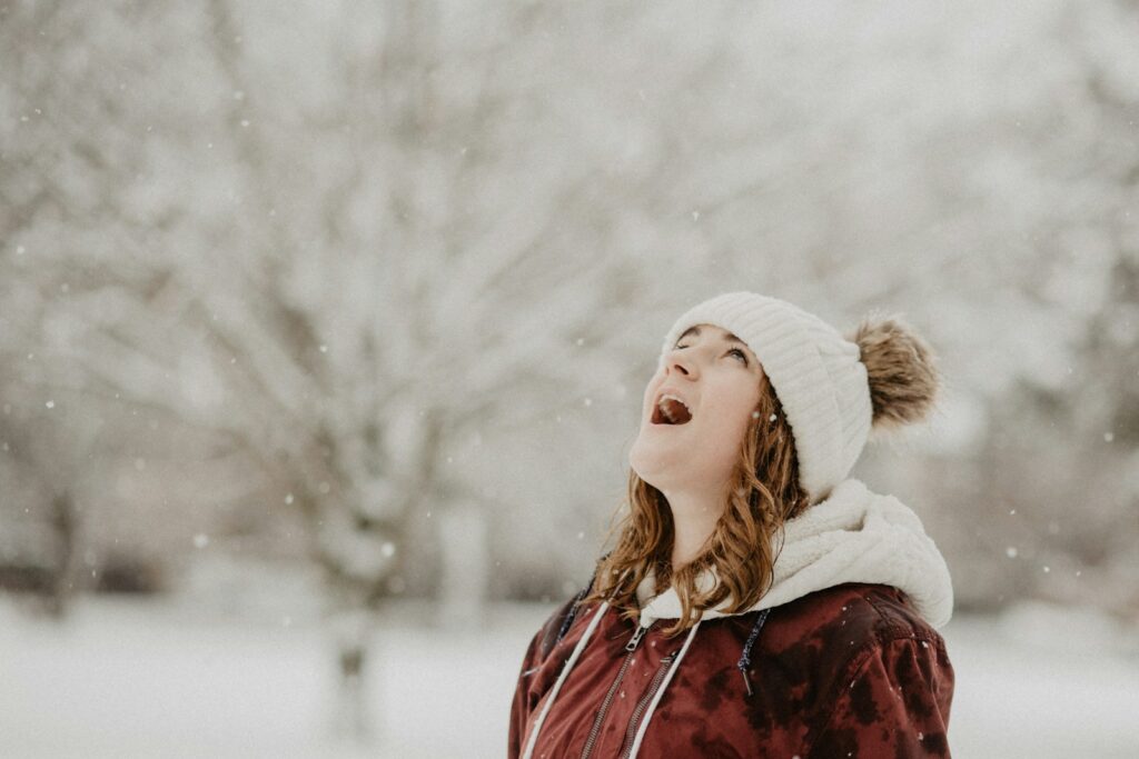 a weather weenie - woman wearing bobble cap looking upwards selective focus photography